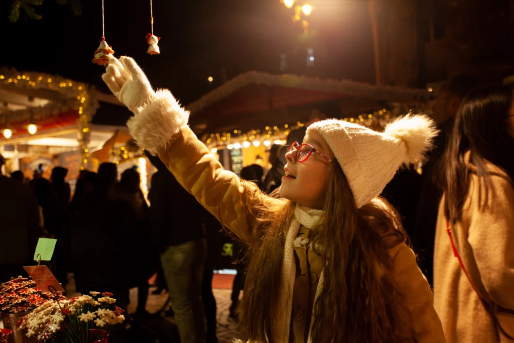Young girl choose Chriastmas toy at the magic Budapest Christmas Market