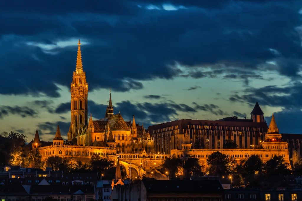 A sunset  shot of Matthias Church illuminated at night and Fisherman's Bastion in the foreground
