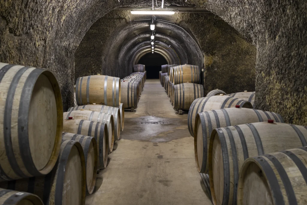 Traditional wine cellar with wooden barrels aging Egri Bikavér red wine near Eger, Hungary.